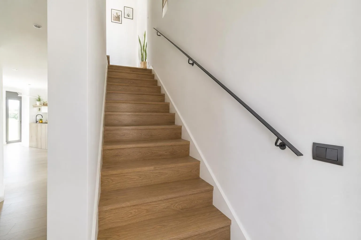 Escalera reformada con peldaños de madera y barandilla sencilla